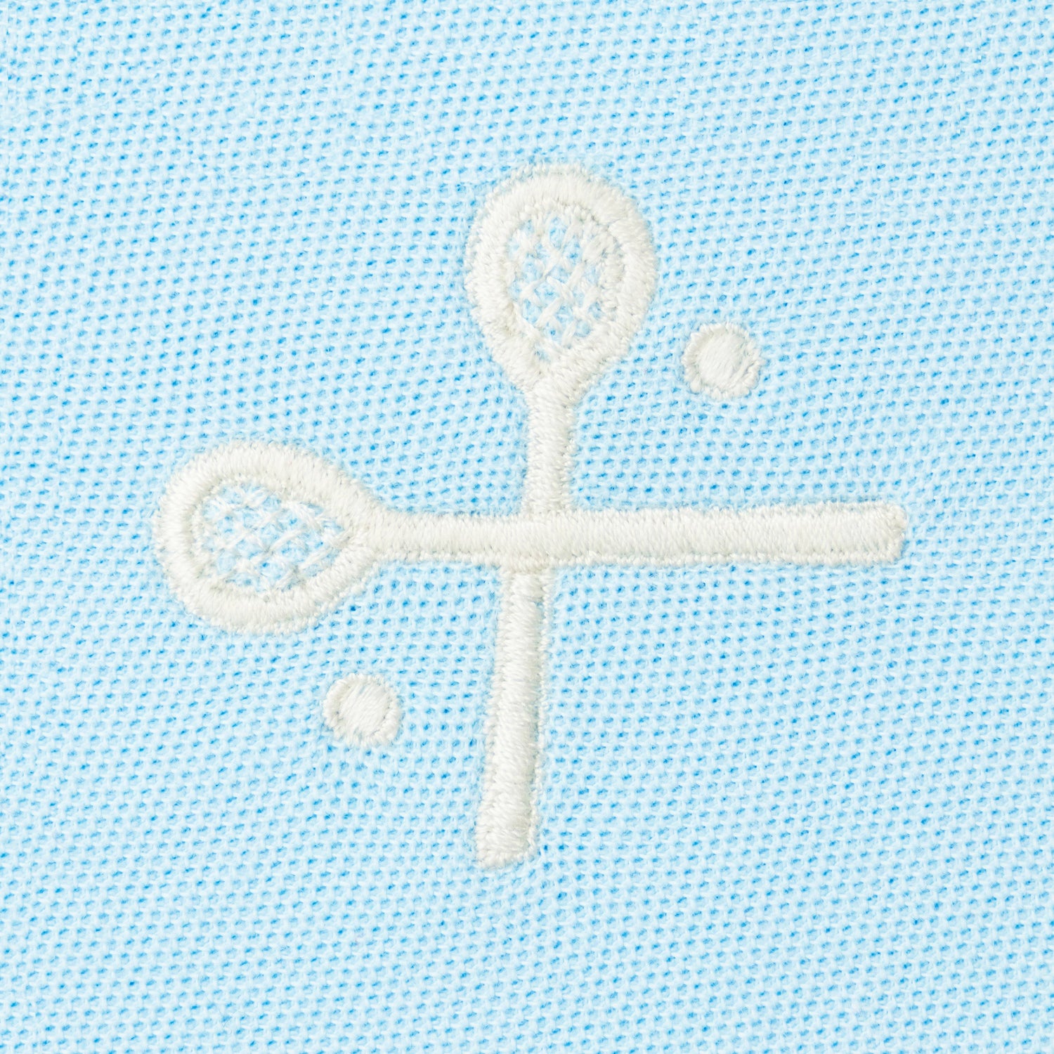 White embroidered crossed racquets motif on light blue polo.