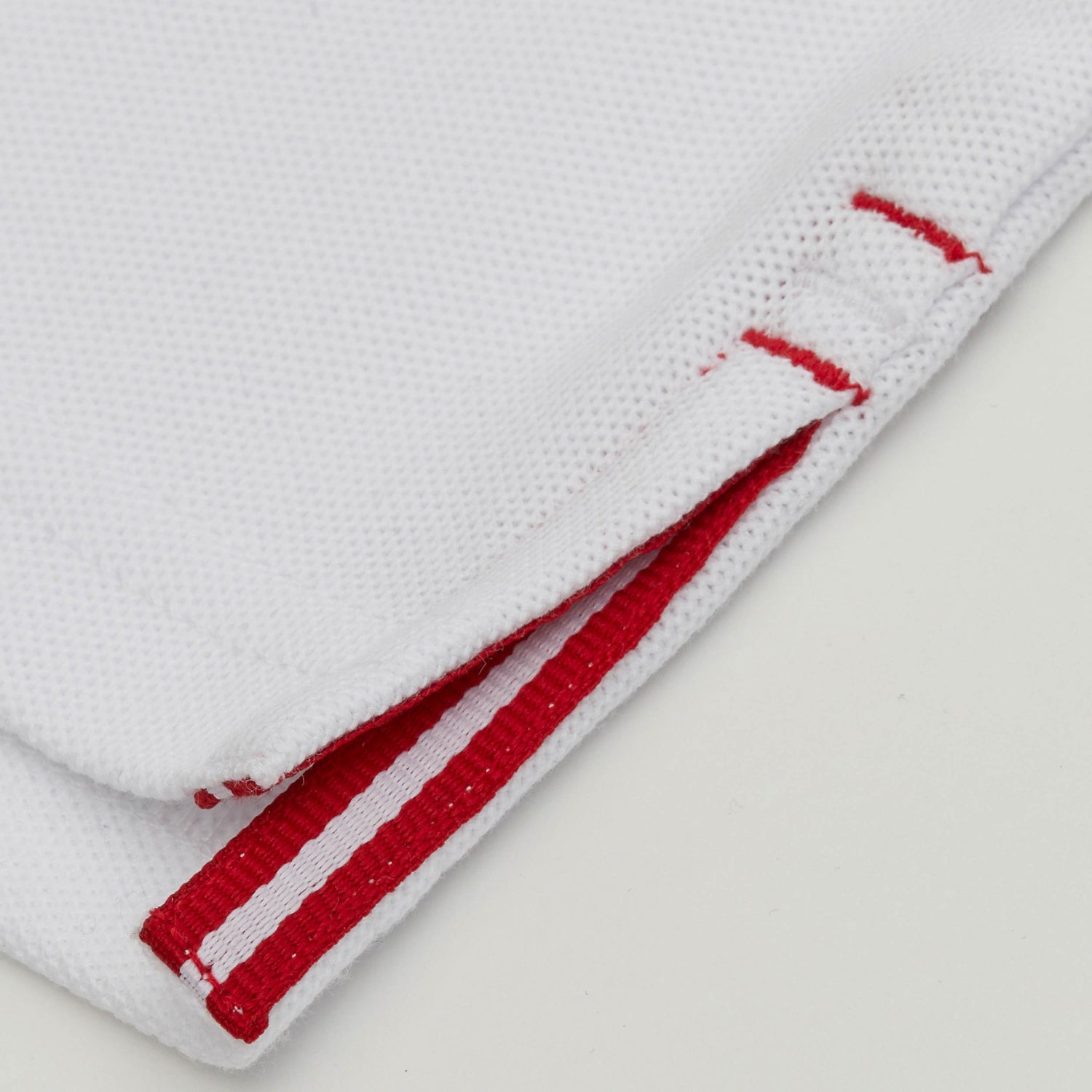 Red and white grosgrain detail on side vent.