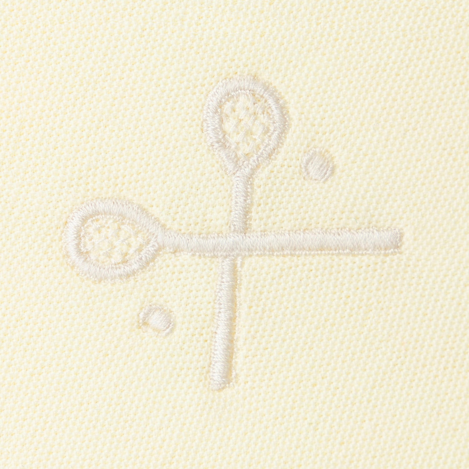 Yellow embroidered crossed racquets motif on yellow polo.