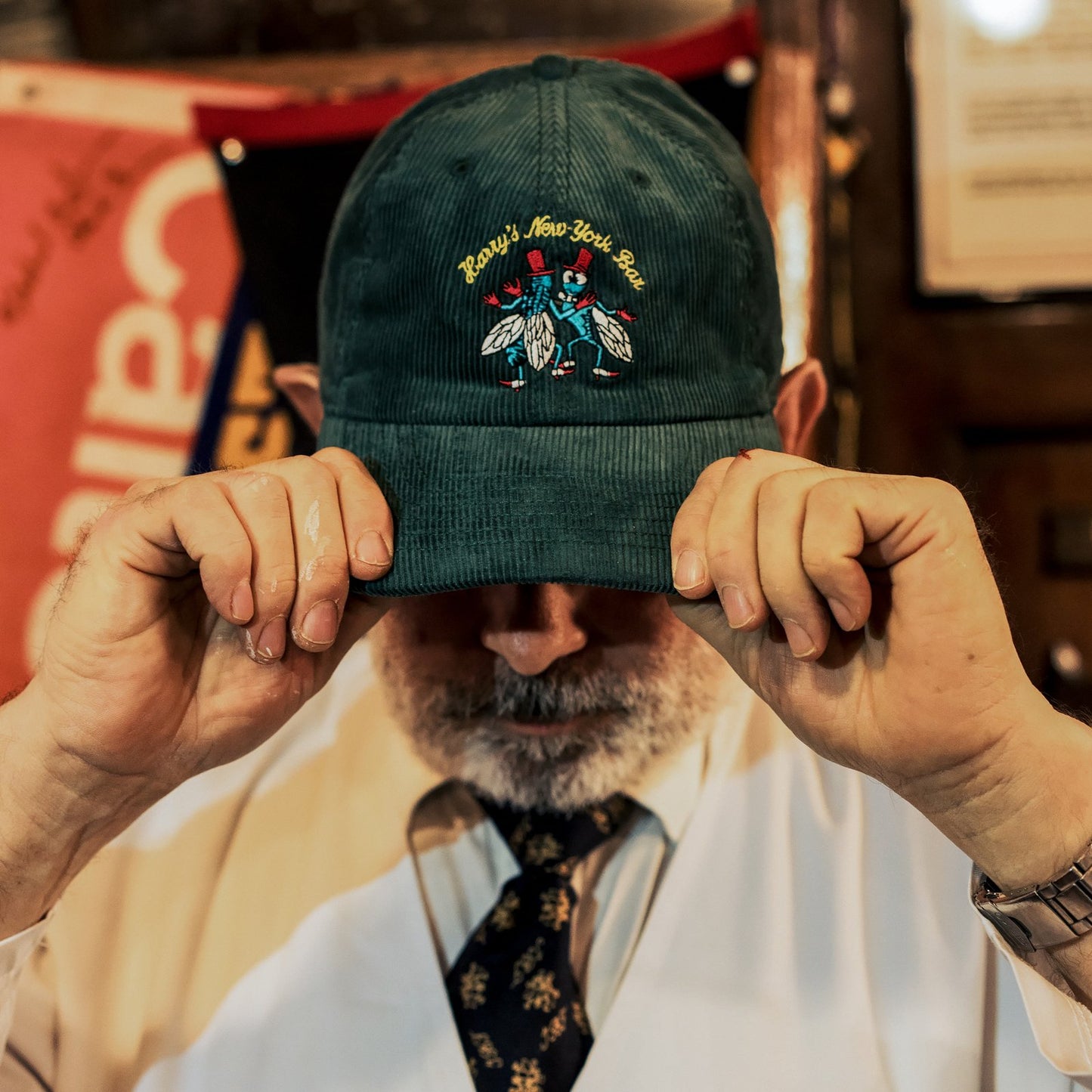 Dark green corduroy dad hat satin-stitched with Harry's famous bar flies motif.