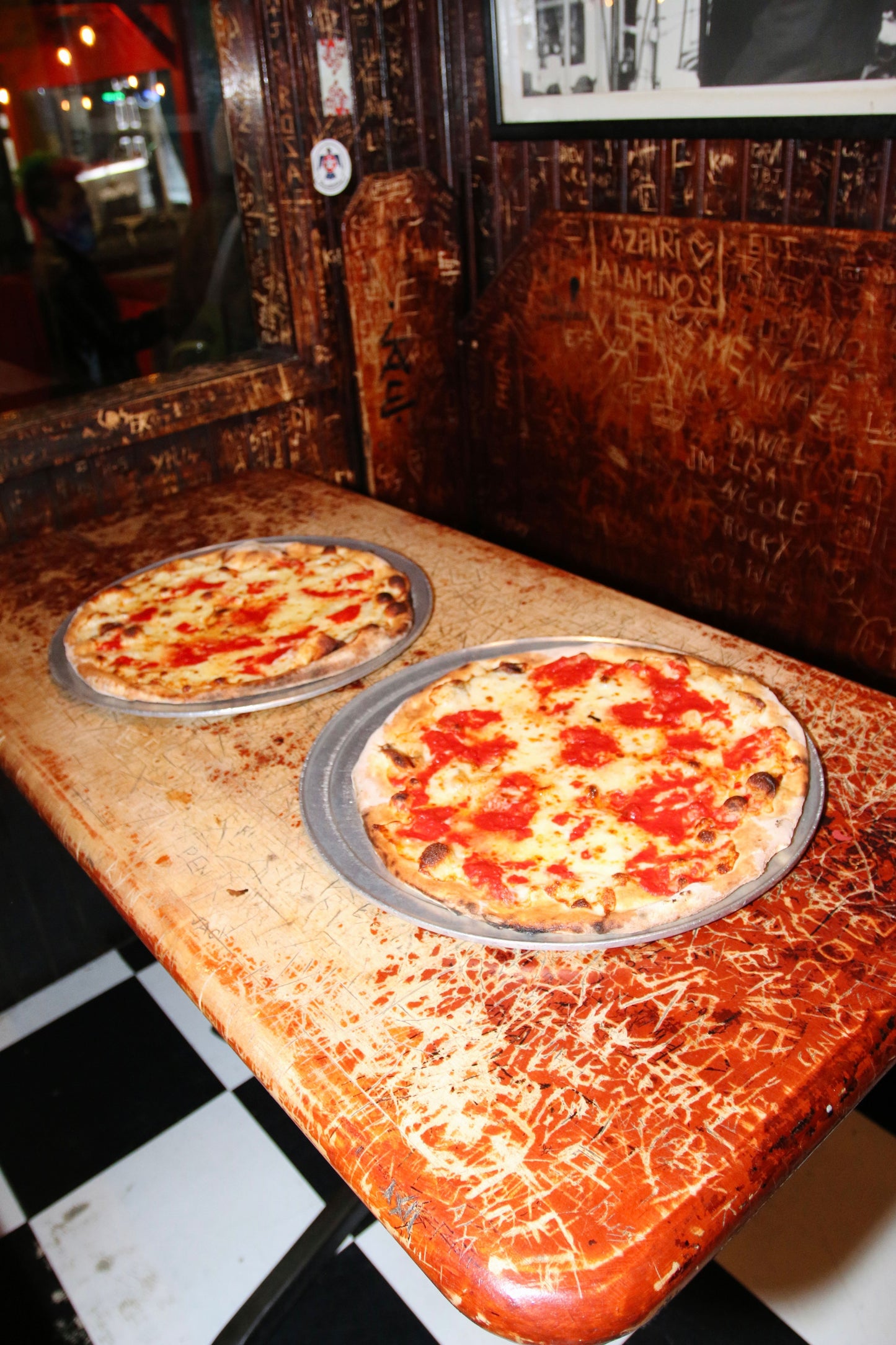 2 Pizzas on top of a table at the restraurant