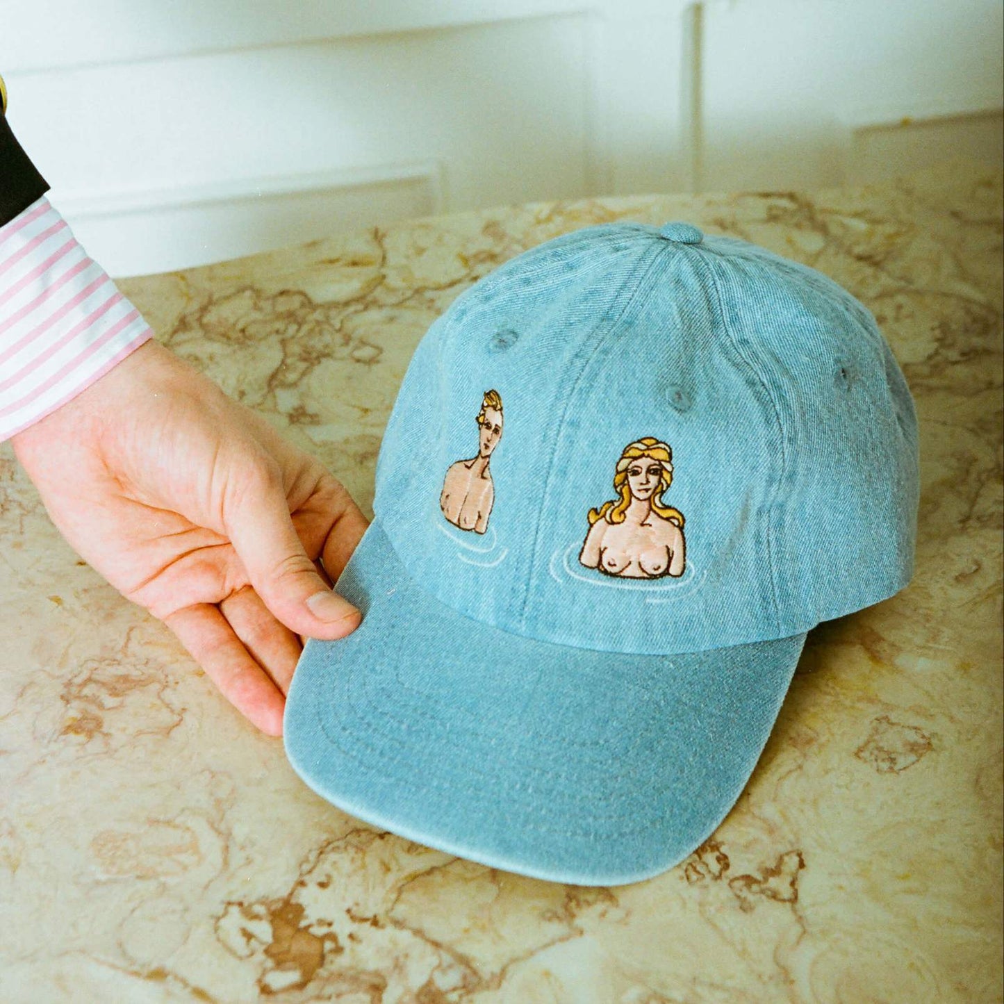 Light blue hat embroidered with Adam & Eve motif.