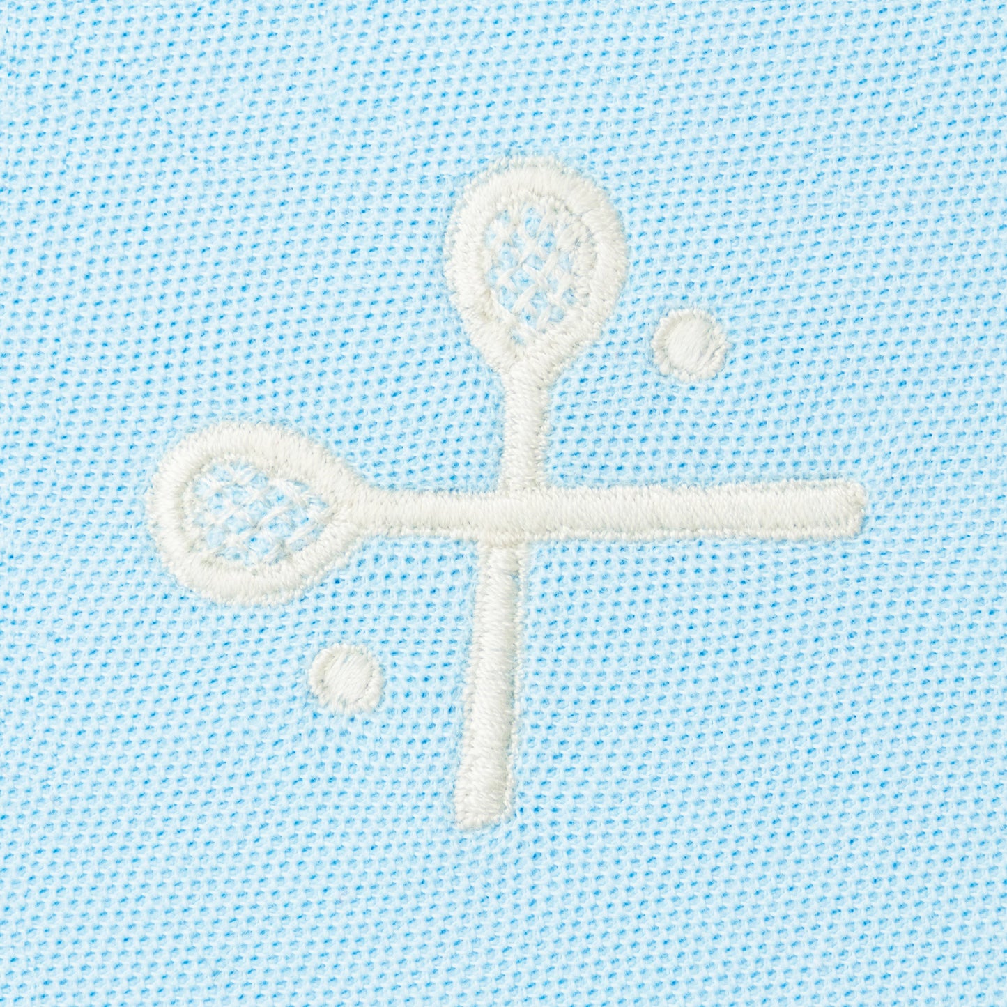 White embroidered crossed racquets motif on light blue polo.