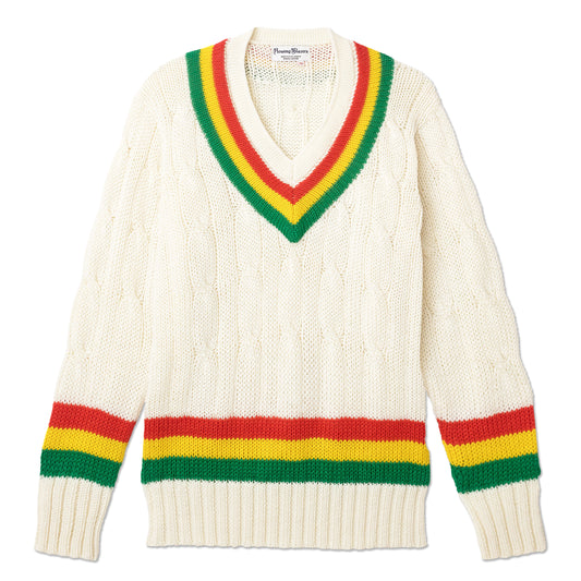 Cable knit cream cricket sweater with red, yellow, and green stripes around the collar, sleeves, and waist.