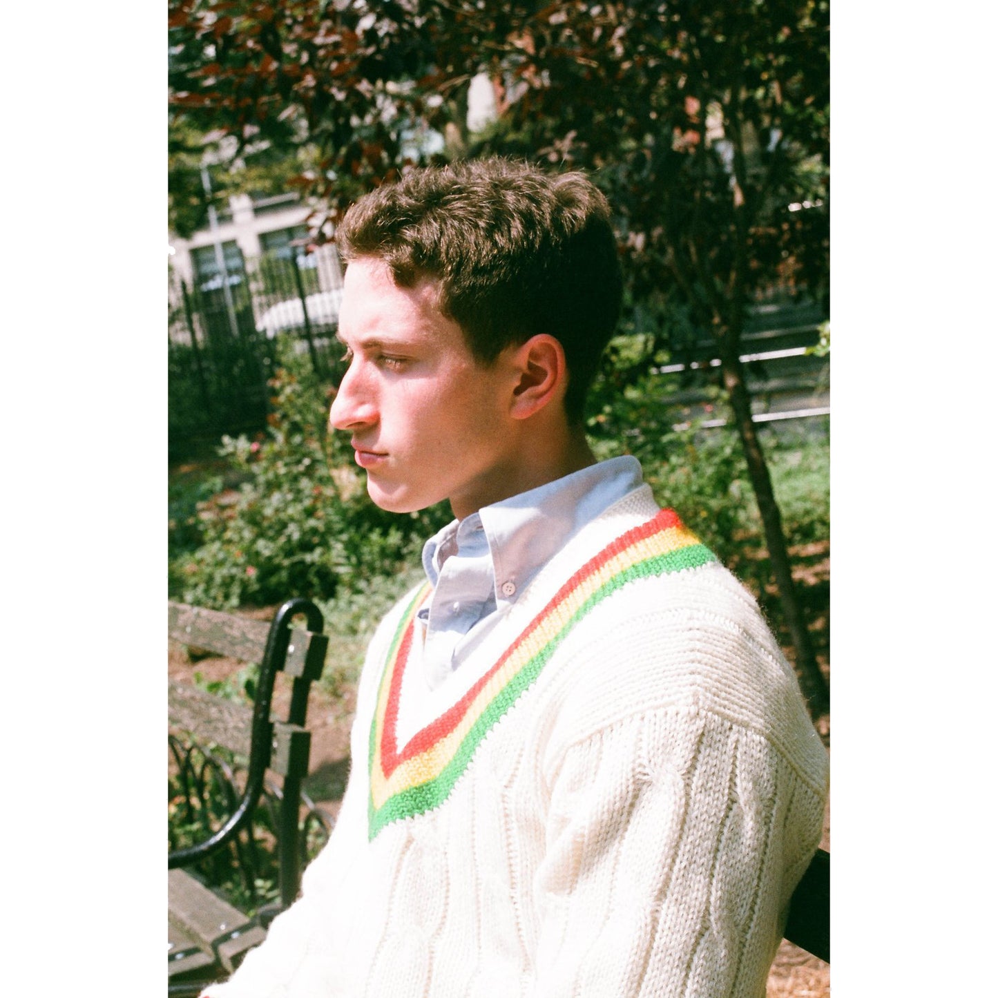 Male model wearing the Cream Wool Cricket Sweater in Red, Yellow, and Green Stripe.