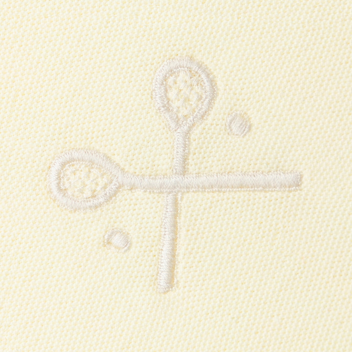 Yellow embroidered crossed racquets motif on yellow polo.