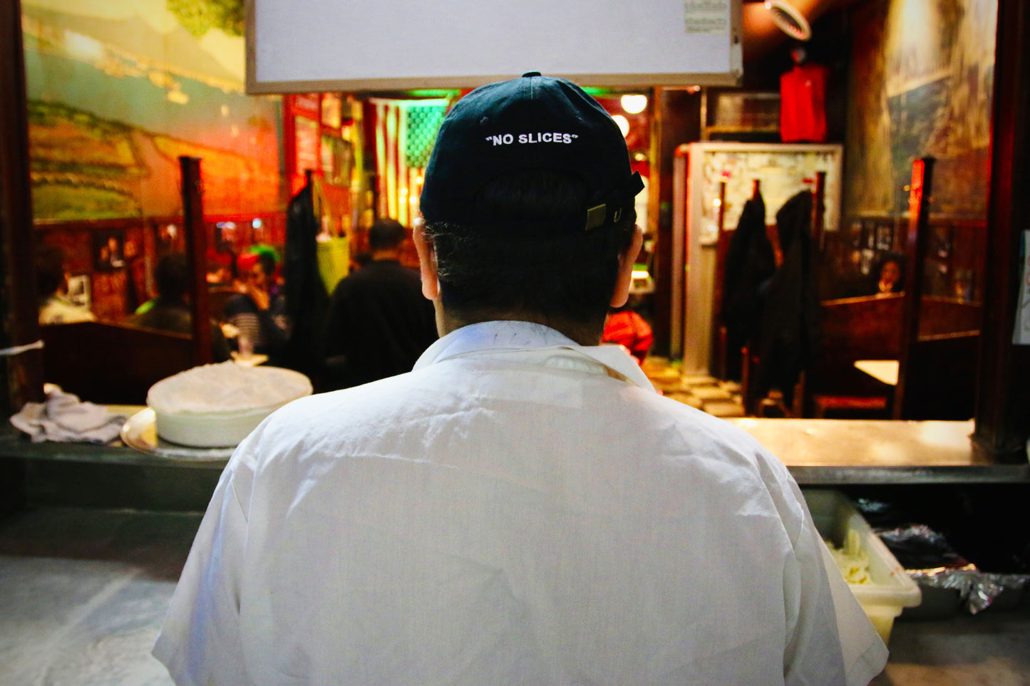 Man wearing the John's Pizza "No Slices" Hat 